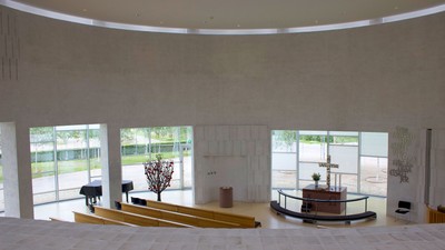 Stor, rummelig hall med store vinduer og minimalistisk indretning