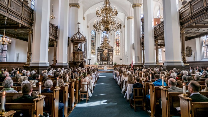 En stor kirke med mange tilstedeværende ved en gudstjeneste.