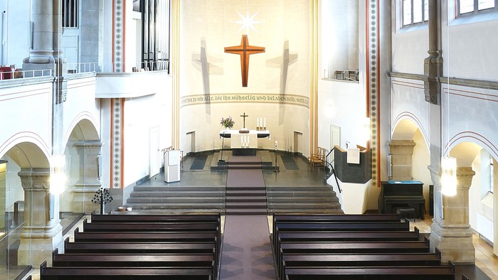 Innenraum einer Kirche mit Holzbanken und hohem Gewoelbe