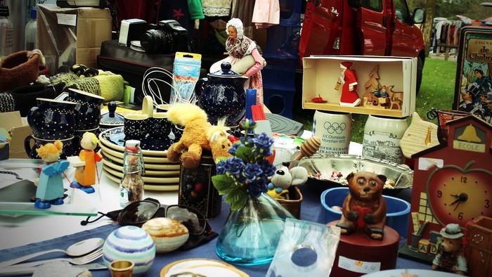 Vielseitiger Trödelmarkt mit diversen Gegenständen wie Vasen, Uhren, Puppen und mehr