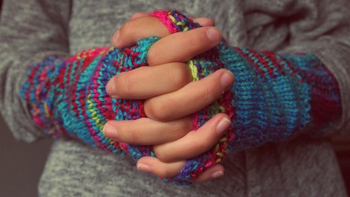 En person med farverige strømper og en grau trøje.