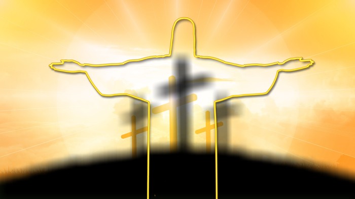 Et guldtone skikkelse af Jesus Kristus på korset med sollys i baggrunden