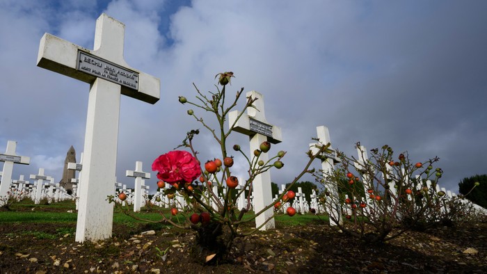 Ein Friedhof mit weißen Kreuzen und Blumen.