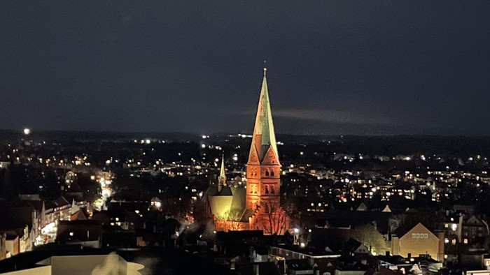 Nachtsicht auf Stadt mit beleuchteter Kirche und Kirchturm