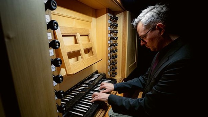 Mann spielt Orgel in Kirche