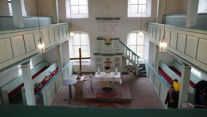 Kircheninneres mit Kirchenbänken, Altar und Buntglasfenstern