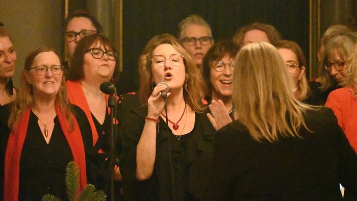 En gruppe kvinder synger i kor.