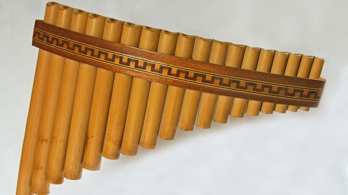 Ein hölzernes Panflöte Instrument auf weißem Hintergrund