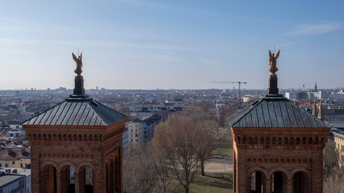 Zwei Türme mit Statuen in einer Stadtlandschaft