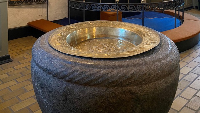 En stor, rund stenfontæne med en guldfarvet indeløbende rand.