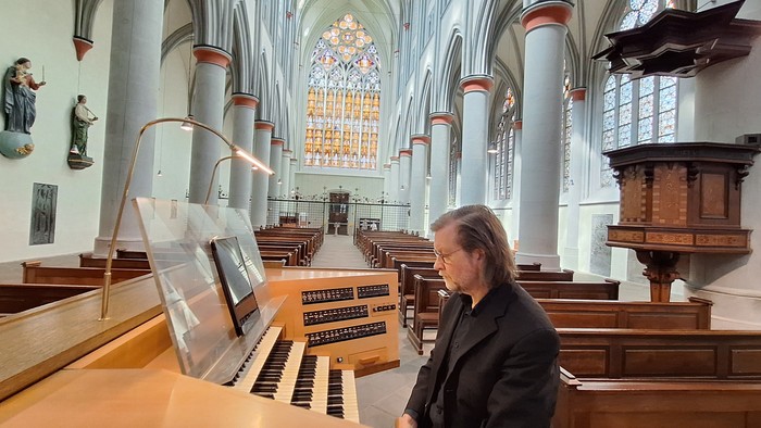 Mann spielt Orgel in großer Kirche