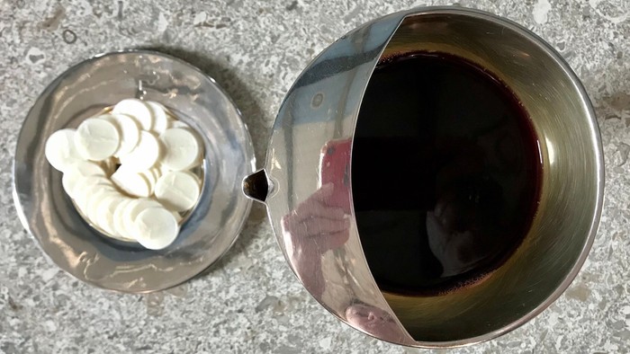 En lille bol med fløde og en stor bol med mørkt drikke.