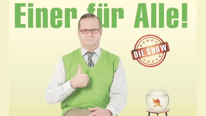 Mann in grüner Weste hält Daumen hoch, "Einer für Alle!" und "NOW" auf Banner.