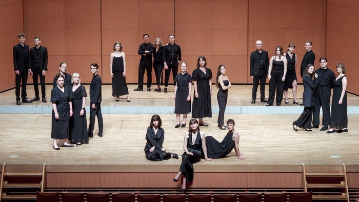 En gruppe dansere på scene i sort og hvidt tøj.