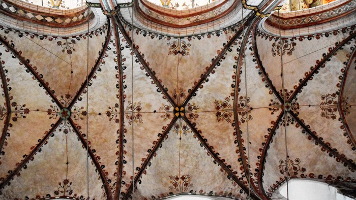 Komplexe geometrische Muster zieren die Decke, mit sich kreuzenden Linien und floralen Motiven.