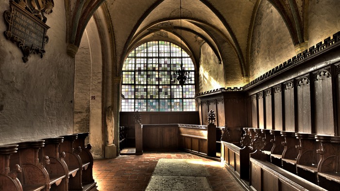 Altes Kirchenschiff mit hölzernen Bänken und Bogenfenster