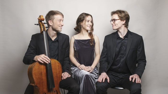 En trio af musikere poserer med deres instrumenter.