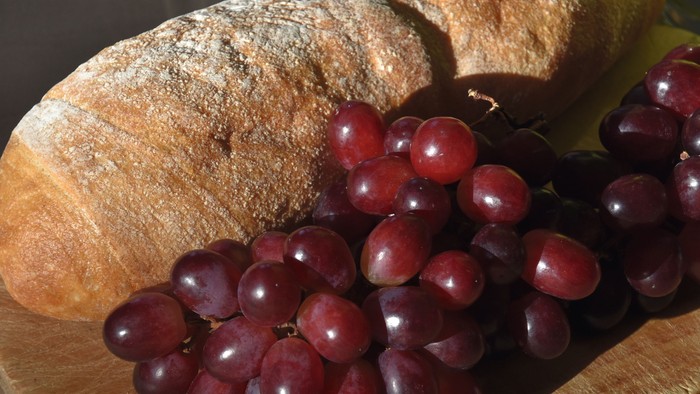 Brot und Trauben auf einem Holzbrett