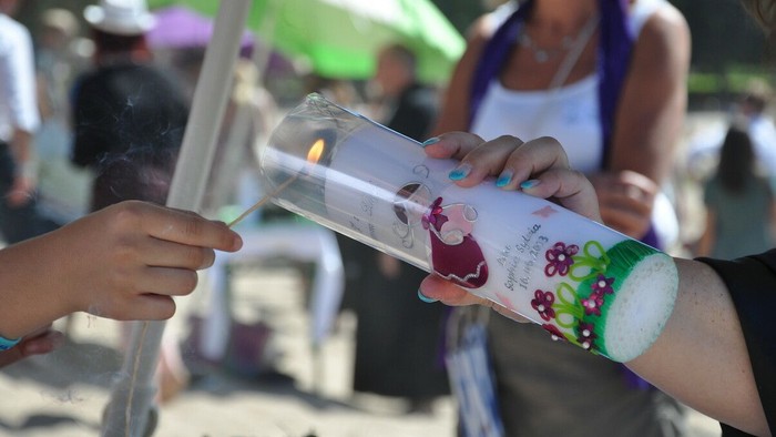 Zwei Personen tauschen eine Flasche mit einem Etikett aus