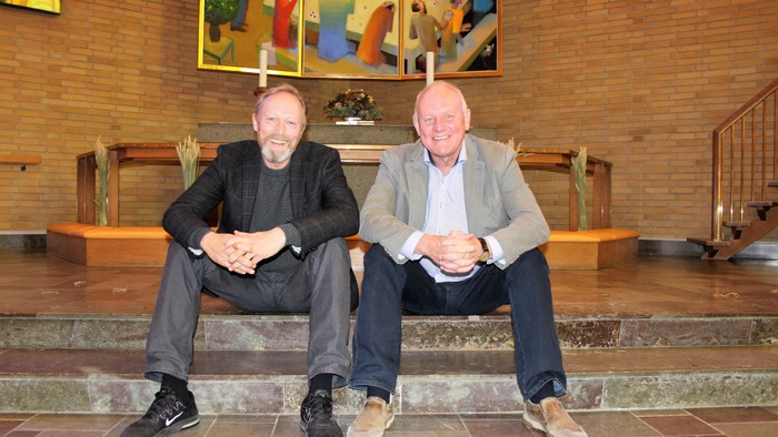 To old mænd sidder på trin og smiler til kameraet