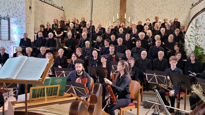 Ein großer Chor und Orchester proben in einer Kirche
