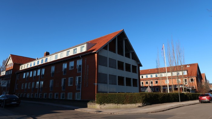 Stor rød bygning med mange vinduer og tag.