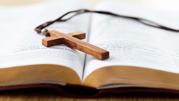 Holzkreuz auf aufgeschlagenem Buch