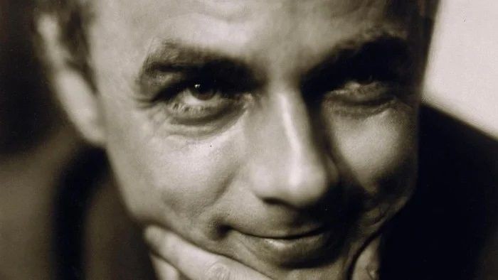 Ein Mann mit nachdenklichem Gesichtsausdruck, Hand am Kinn.