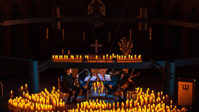 Streichquartett im Altarraum der Apostel-Paulus-Kirche, umgeben von Lichtern am Boden