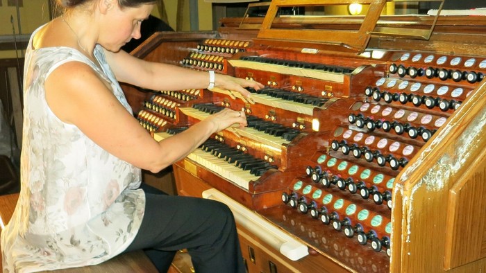 Frau spielt Orgel in Kirche