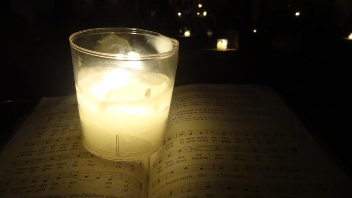 Ein brennendes Teelicht im Glas in der Dunkelheit