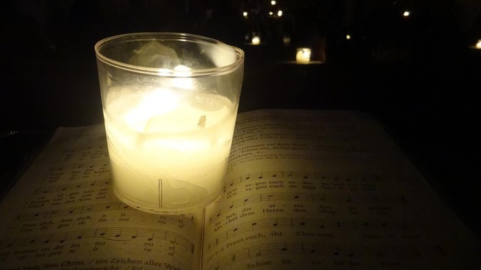 Ein brennendes Teelicht im Glas in der Dunkelheit