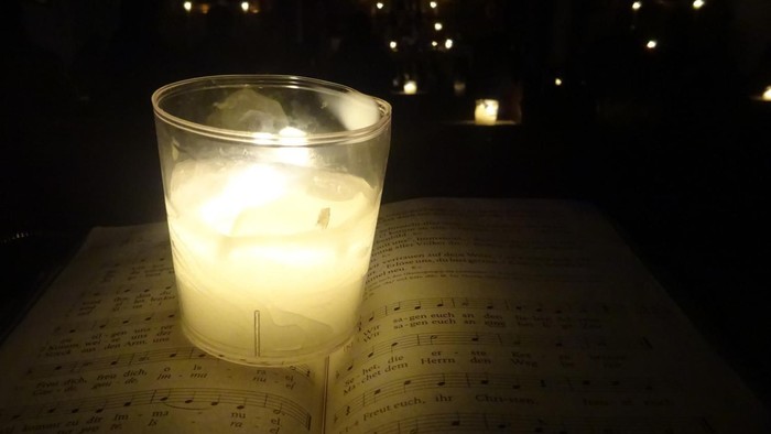 Ein brennendes Teelicht im Glas in der Dunkelheit