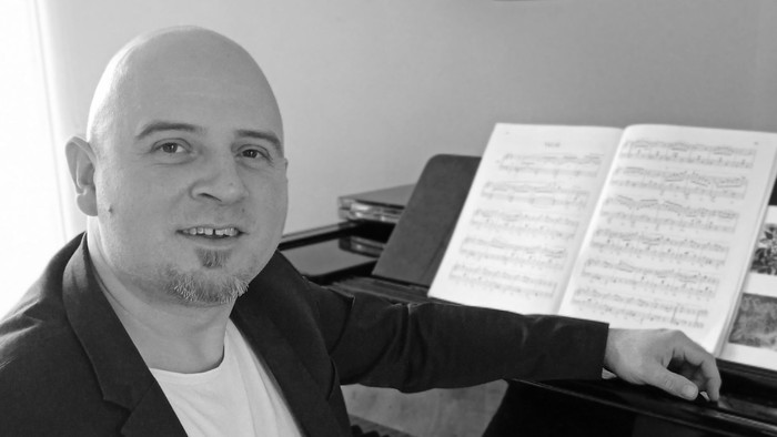 Mand spiller piano og ser glade ud