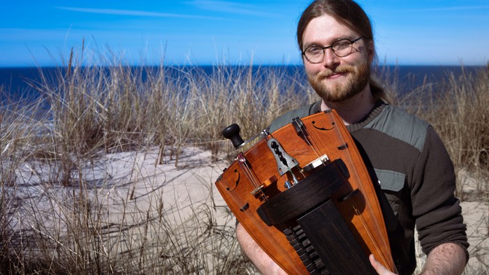 Mand på strand med orange instrument