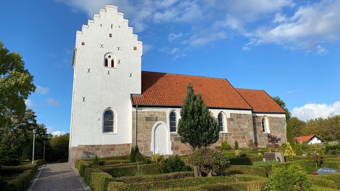 En smuk kirke med klokketårn og en fin have