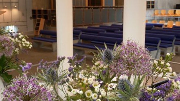 Indre del af kirke med blomster og lysstake