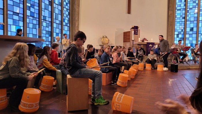 Kinder, die in einer Kirche Trommeln spielen