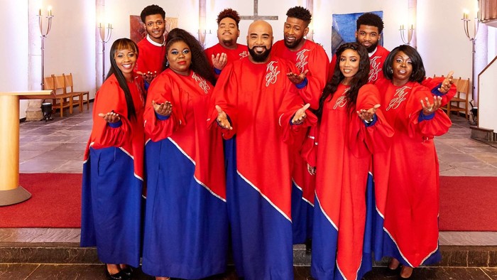 Eine Gruppe von Menschen in roten und blauen Roben posiert in einer Kirche