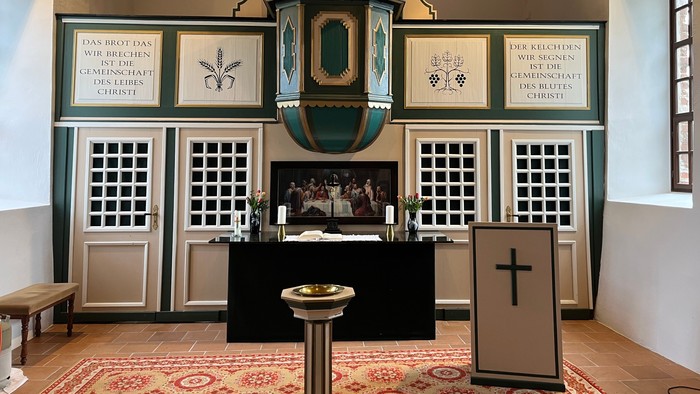 In der Kirche: Altar, Kanzel, Taufbecken, Orgel, Kreuz.