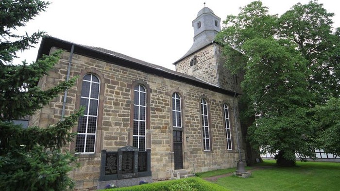 Steinkirche mit Rundbogenfenstern und kleinem Turm.