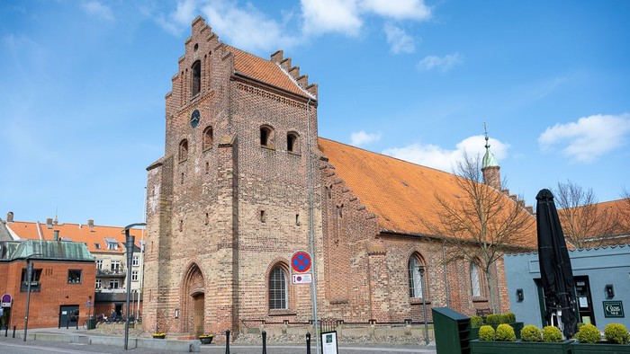 Gamle kirke med teglmur og spistegning i bymiljø