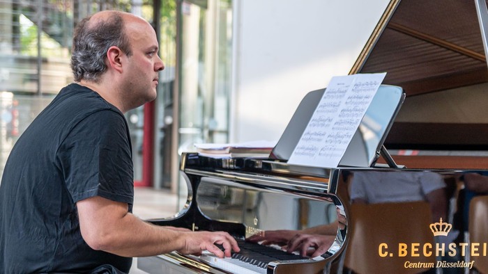 Mann spielt Klavier in modernem Raum