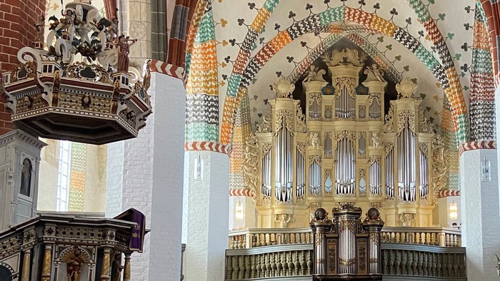 Die Kirche hat eine prächtige, verzierte Orgel und bunte Deckenbalken.