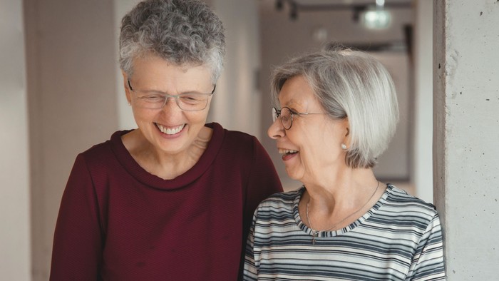 Zwei ältere Frauen lachen und unterhalten sich.