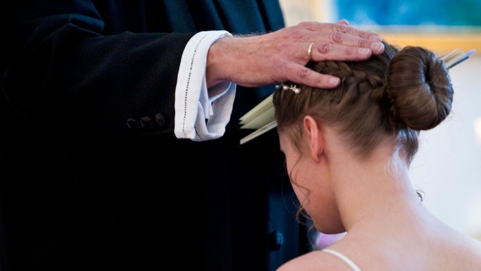 En kvinde får sit hår stillet af en frisør.
