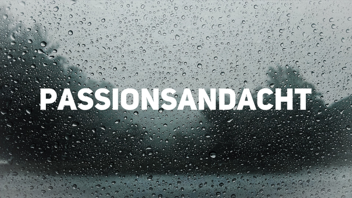 Regen auf einer Windschutzscheibe mit der Aufschrift "PASSIONSANDACHT"