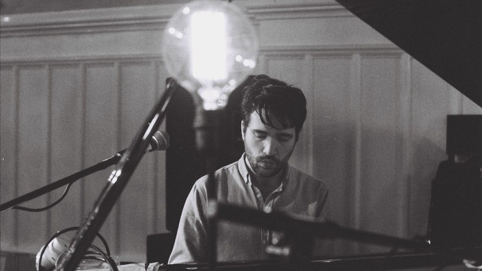 Mand spiller piano under lyset