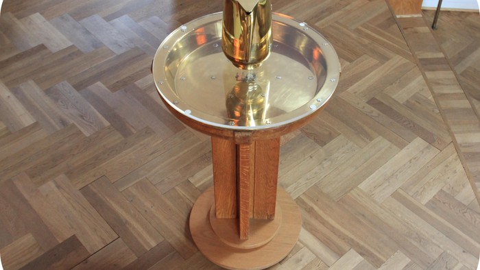 Gul og sølv drikkefontæne på trægolvet