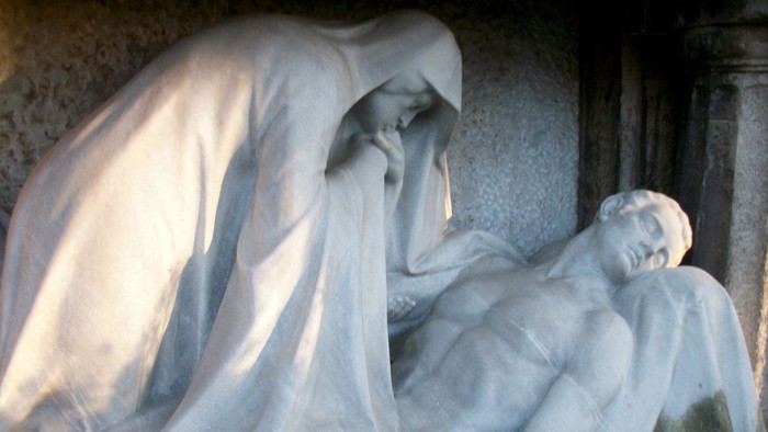 Trauernde Figur hält zärtlich einen verstorbenen geliebten Menschen in einer ergreifenden Marmorskulptur.